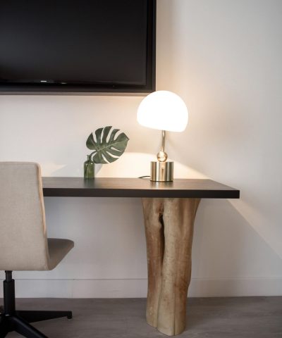 Elegantly designed modern workspace featuring a unique wood table, chair, and lamp.